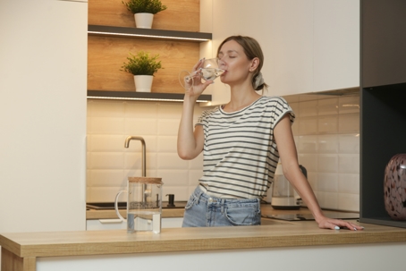 Young woman drinking water from glass